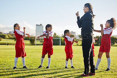 Buy stock photo Fitness soccer, girl team and stretching with sport coach on sports field training, exercise or workout. Children, kids or  coaching in diversity, teamwork and collaboration on warm up for game.
