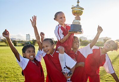 Buy stock photo Trophy, winner and football children with success, winning and excited celebration for sports competition or game on field. Happy soccer girl kids team with motivation, celebrate winning achievement