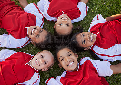 Buy stock photo Happy football children relax on field sports portrait for group collaboration, teamwork and motivation. Soccer girl kids face lying on ground together for training support, love and commitment above