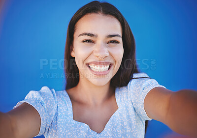 Buy stock photo Portrait of girl taking a selfie with blue background and smile on face. Mockup for summer, fashion and beauty with happy, smiling and young woman with natural beauty taking a photo and having fun