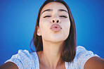 Taking a selfie, kiss and portrait of girl on blue background with natural beauty. Mockup for young woman with beauty, fashion and face makeup in summer. Love, cosmetics and kissing lips pose