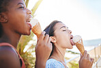 Children, ice cream and summer with girl friends eating a sweat treat on the beach during summer vacation. Kids, food and icecream with a female child and friend enjoying a cold snack on a warm day