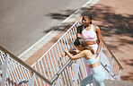 Fitness, exercise and friends stretching on stairs before running in a city together, wellness and cardio. Training, women and workout practice by girls bonding and relax, discussing run routine