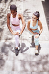 Fitness, exercise and stretching with girl friends on steps in the city for workout or training. Sports, health and wellness with a black woman and friend exercising outside in town from above