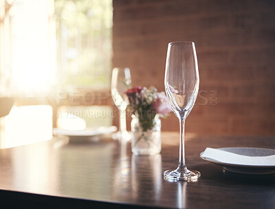 Buy stock photo Empty glass on table for wine, champagne or alcohol at dinner in romantic restaurant, home or diner. Luxury, lunch or supper with crystal wine glass, plate and flower for reception, banquet or meal