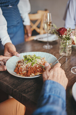 Buy stock photo Food, restaurant and hands with a couple and waitress serving a pasta in a fine dining establishment. Date, romance and together with a senior man and woman enjoying eating on their anniversary