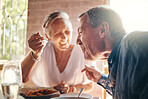 Couple, love and food with a senior man and woman on a date in a restaurant while eating on holiday. Travel, romance and dating with an elderly male and female pensioner enjoying a meal together