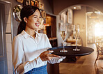 Waitress, wine glass tray and hospitality service in restaurant, cafe and fine dining winery. Happy woman, bartender and sommelier catering luxury champagne, alcohol glasses or expensive liquor drink