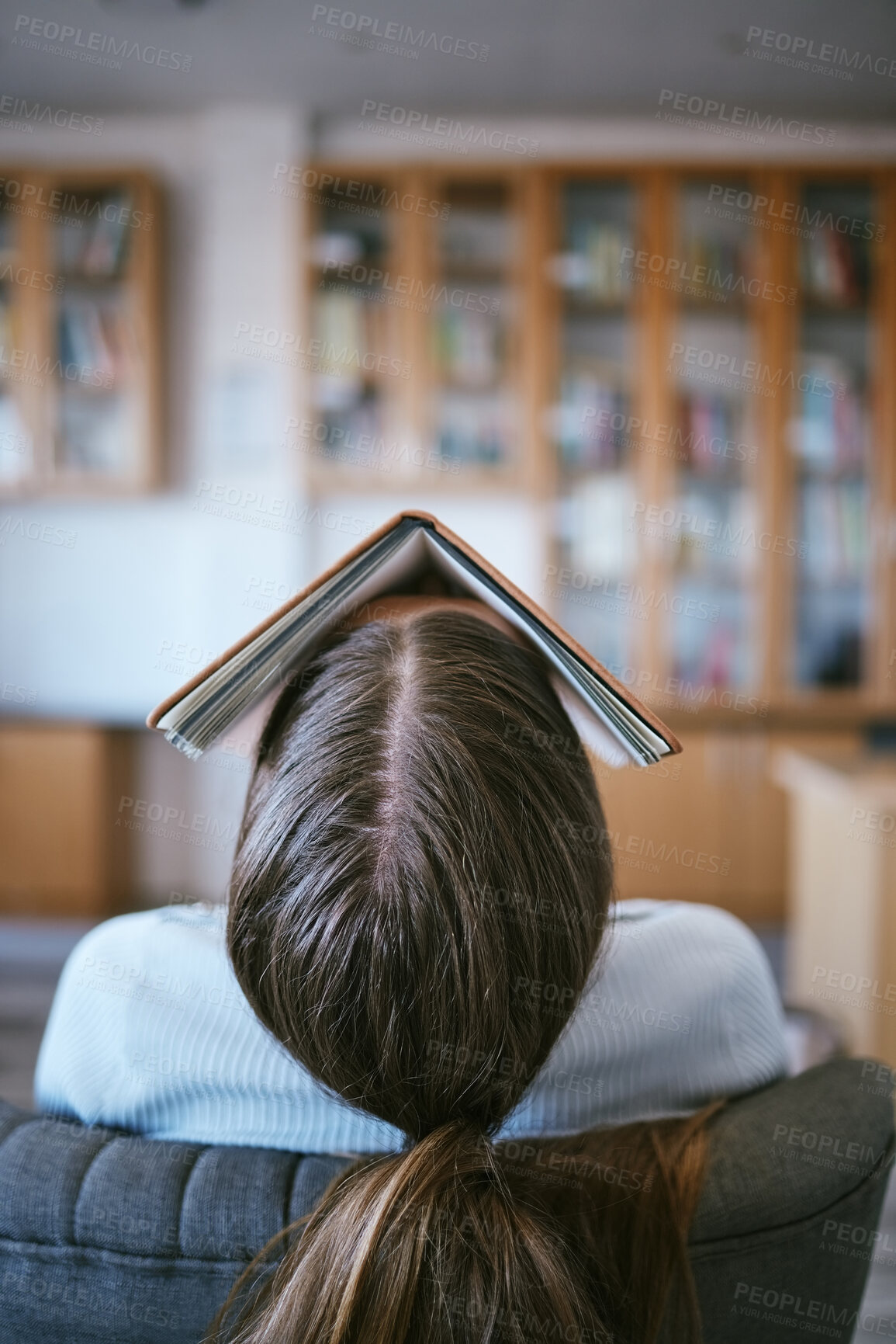 Buy stock photo Burnout, tired and sleeping student with book on face in university library learning, education or reading problem. Fatigue, frustrated or bored college woman and research studying for language exam