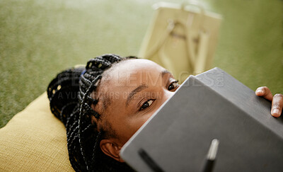 Buy stock photo Black woman and student hiding face with notebook on casual college study lounge bean bag. Shy African university learner on studying rest break looking with lecture book to hide identity.