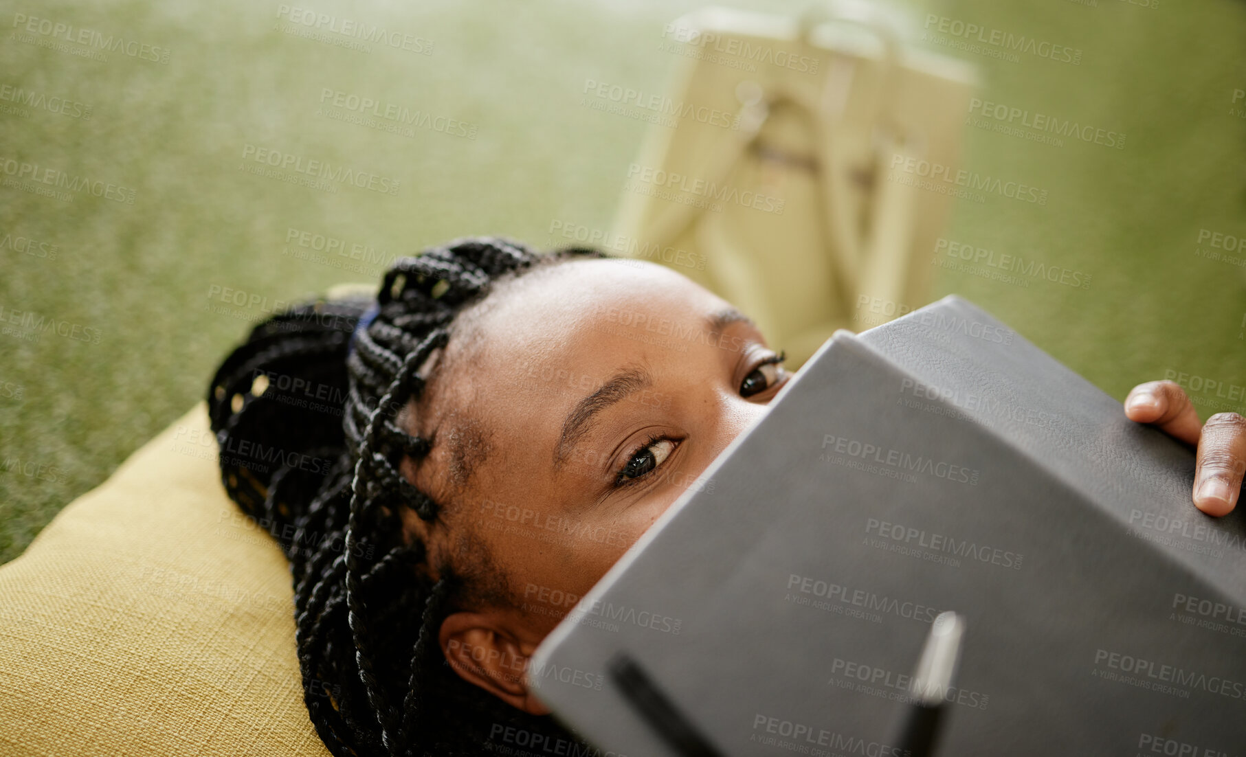 Buy stock photo Black woman and student hiding face with notebook on casual college study lounge bean bag. Shy African university learner on studying rest break looking with lecture book to hide identity.