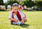 Sports, girl and soccer player with child on grass before outdoor game and exercise. Kids, fitness and shoes during football training, getting ready for exercise and soccer practice on a field