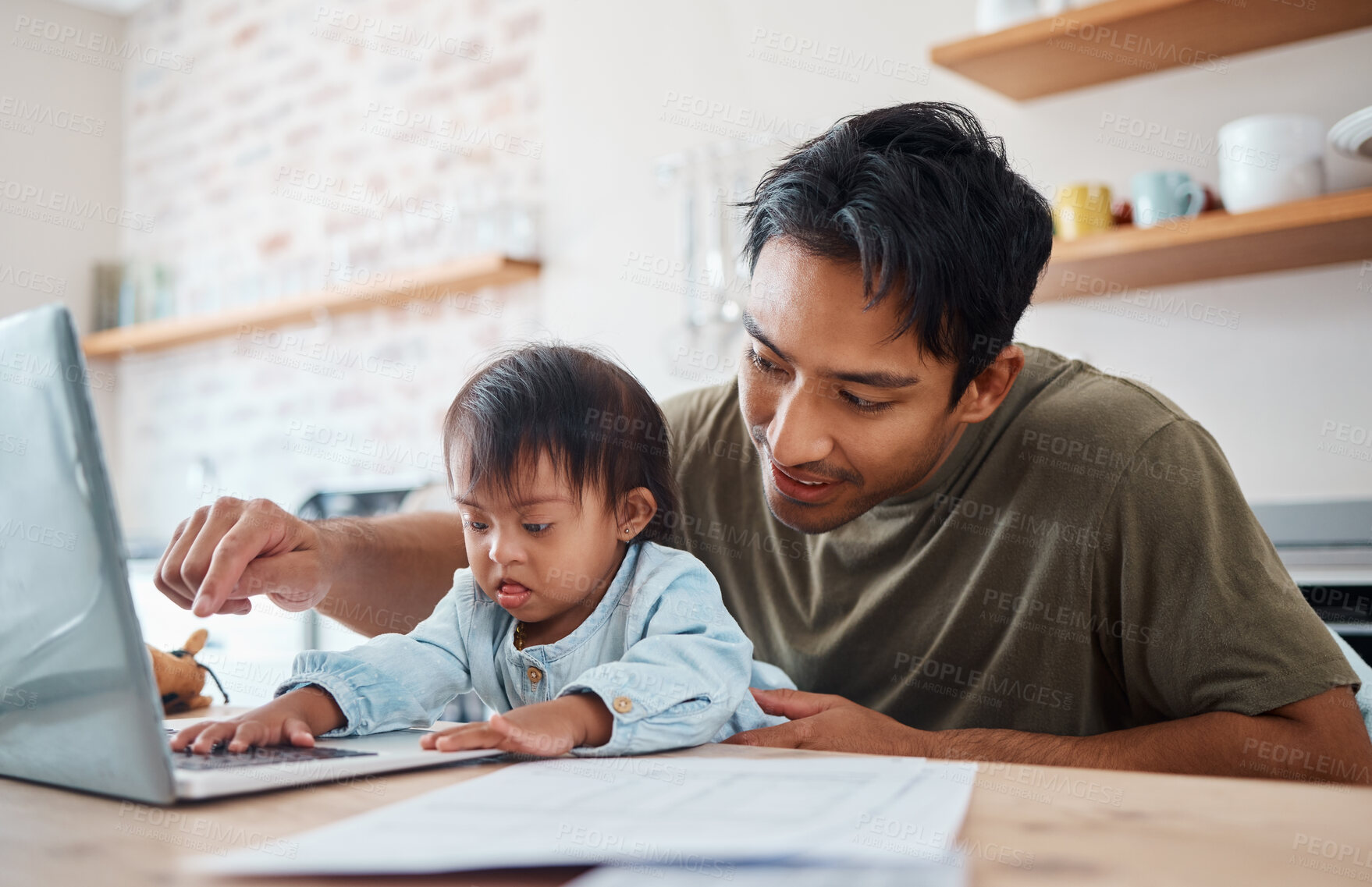 Buy stock photo Father, down syndrome baby and laptop in the kitchen bonding with child while working at home. Asian dad playing with newborn kid with genetic disorder and helping childhood development in the house