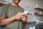 Hands, phone and man texting in a kitchen, relax and smile while reading social media message. Internet, communication and guy planning fun vacation day, streaming and enjoying online app in his home