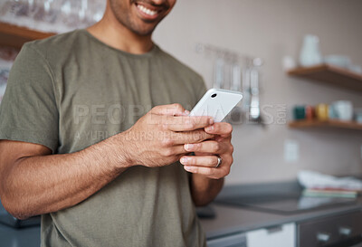 Buy stock photo Hands, phone and man texting in a kitchen, relax and smile while reading social media message. Internet, communication and guy planning fun vacation day, streaming and enjoying online app in his home