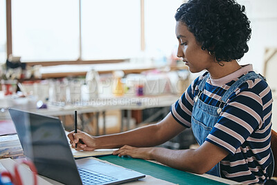 Buy stock photo Laptop, art and education with a woman student in a creative classroom, workshop or studio while writing in a notebook. Computer, learning and school with a female artwork pupil studying in class