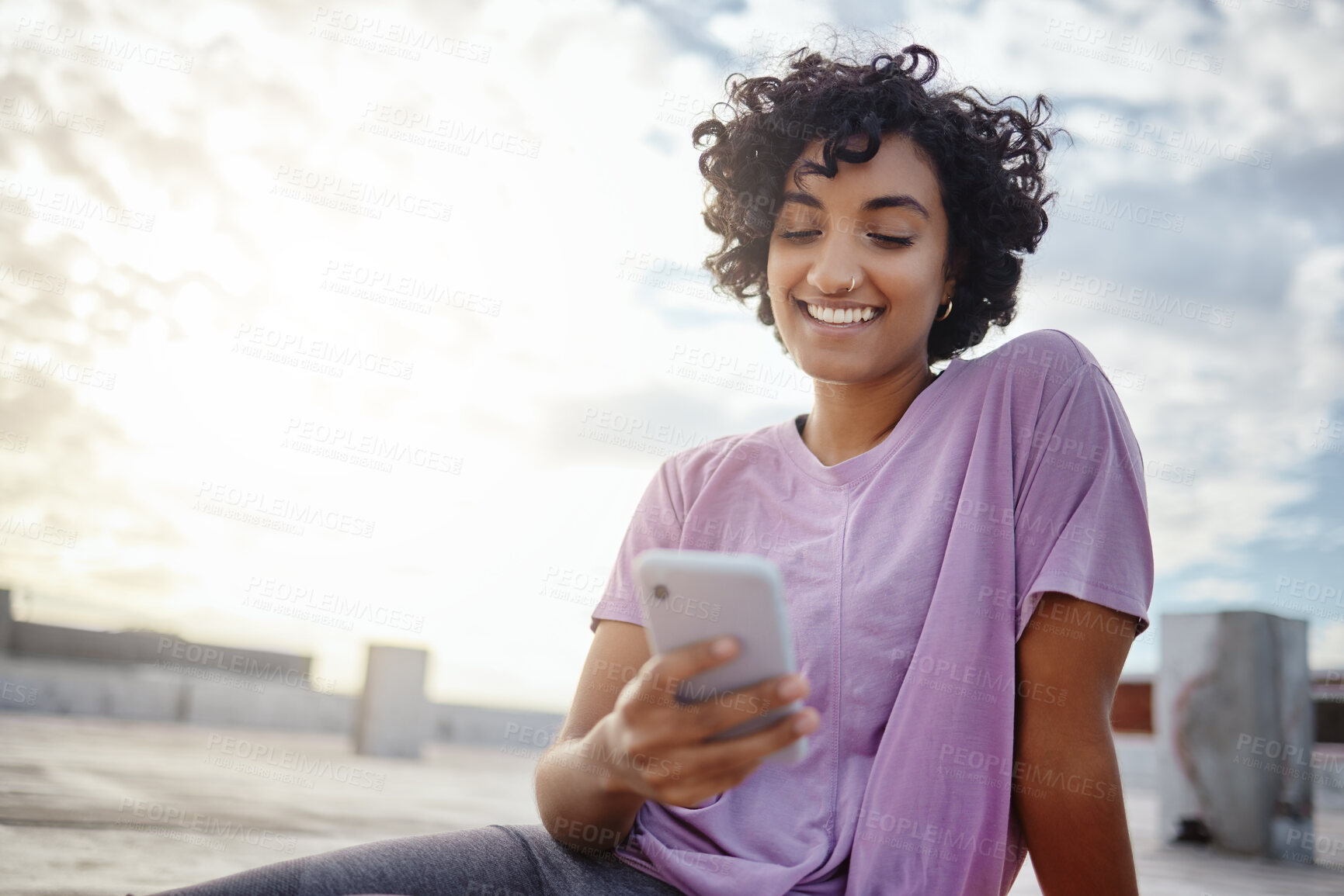 Buy stock photo Phone, social media and communication with a woman in the city on a rooftop, sending or writing a message against a blue sky background. 5g mobile technology, networking and text with a young female