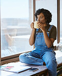 Woman, coffee or thinking by window in studio, Indian art gallery or creative painting workshop with phone or notebook. Artist, designer or painter with technology, ideas or innovation vision and tea