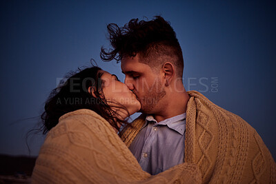 Buy stock photo Kiss, love and winter with a couple at night in a blanket for romance, date or anniversary with a dark blue sky. Kissing, dating and honeymoon with a young man and woman sharing an intimate moment