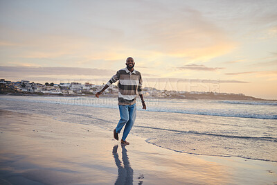 Buy stock photo Beach, freedom and vacation with a black man by the ocean or sea, running on sand with a sunset view of the sky. Nature, water and summer with a young male enjoying a holiday on the coast