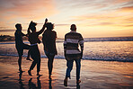 Silhouette, friends and at the beach or sea relax, happy and have fun with sunset view on vacation together. Group, men and women or couples travel, enjoy seaside and ocean holiday weekend bare feet.
