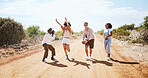 Friends, road trip adventure and desert travel holiday together laugh while walking on dirt road in summer sun. Group diversity, vacation in nature and explore freedom traveling Australia countryside