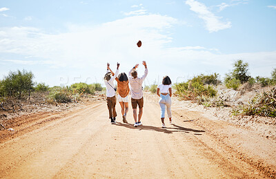 Buy stock photo Summer, adventure and friends walking on dirt road in the country, throwing ball in air. Travel, freedom and young group of men and women on holiday together to explore nature, vacation and blue sky