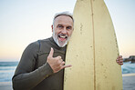 Senior man, with surfboard and at beach smile, happy and show sign at sunset with swimwear on a holiday. Portrait, older and male surfer enjoy day at seaside with surfing while on getaway or vacation