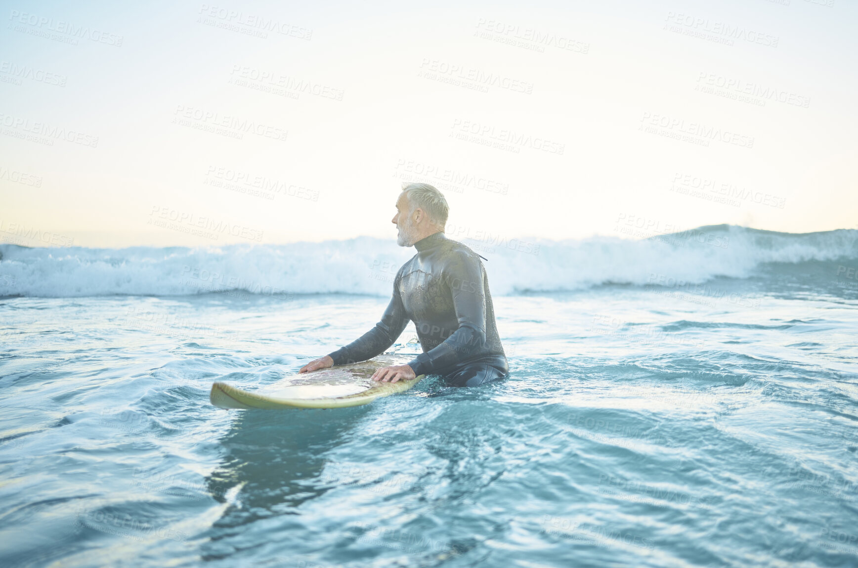 Buy stock photo Swimming, beach and old man in water surfing enjoying a summer holiday vacation his retirement in Los Angeles, USA. Fitness, healthy and senior person waiting for ocean waves on his surfboard at sea
