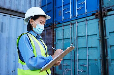 Buy stock photo Covid, shipping logistics and employee writing during inspection at a container warehouse. Asian industrial engineer woman with ecommerce notes and planning delivery of cargo with a face mask