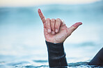 Hand sign, shaka and man in the ocean outdoor in nature while on summer vacation in Australia. Surf culture, hang loose gesture and closeup of hands of friendly surfer in water at beach on holiday.