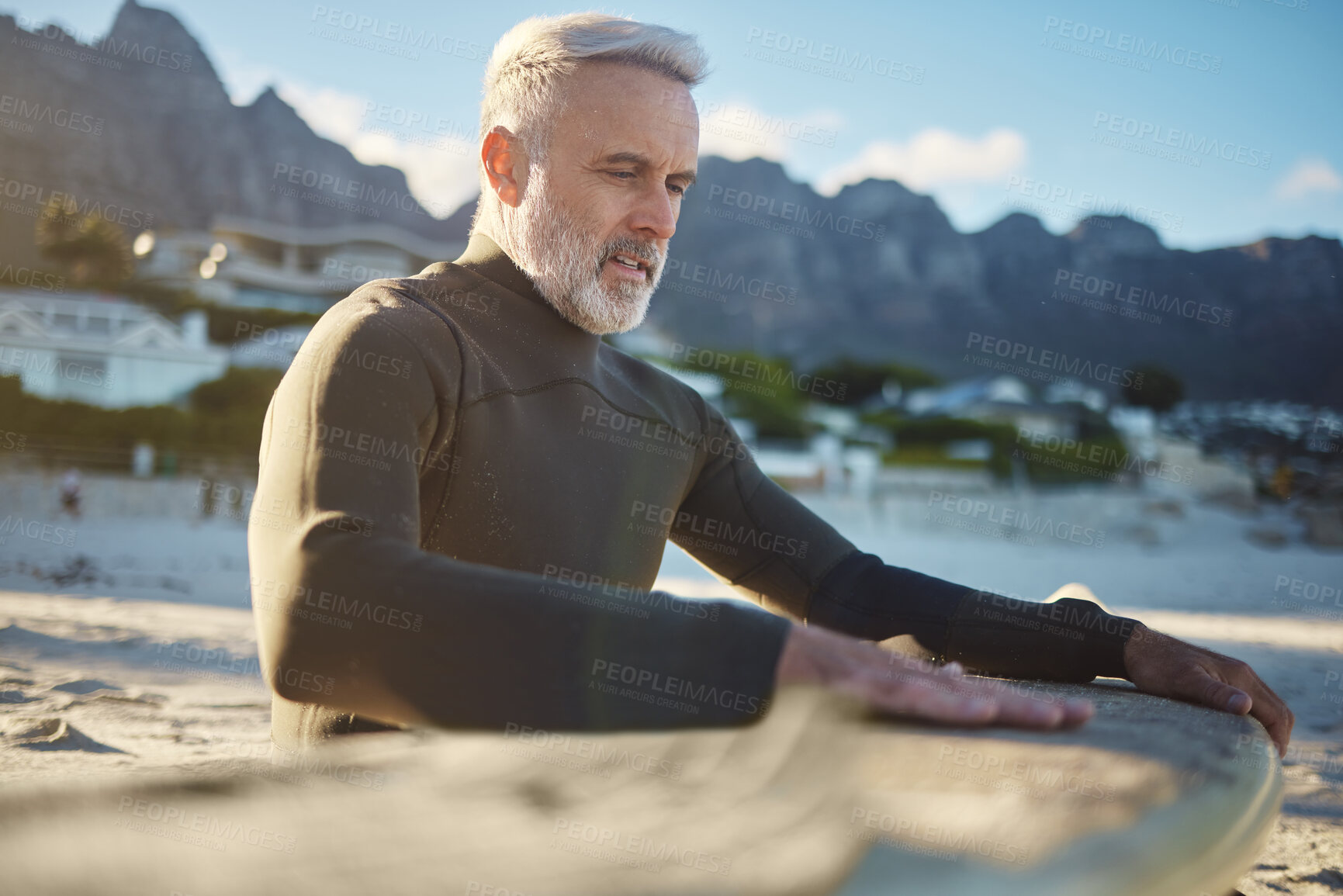 Buy stock photo Surf, sand and sports with a man on the beach for surfing, training or exercise on a summer day. Fitness, workout and travel with a mature surfer cleaning a surfboard while on retirement vacation
