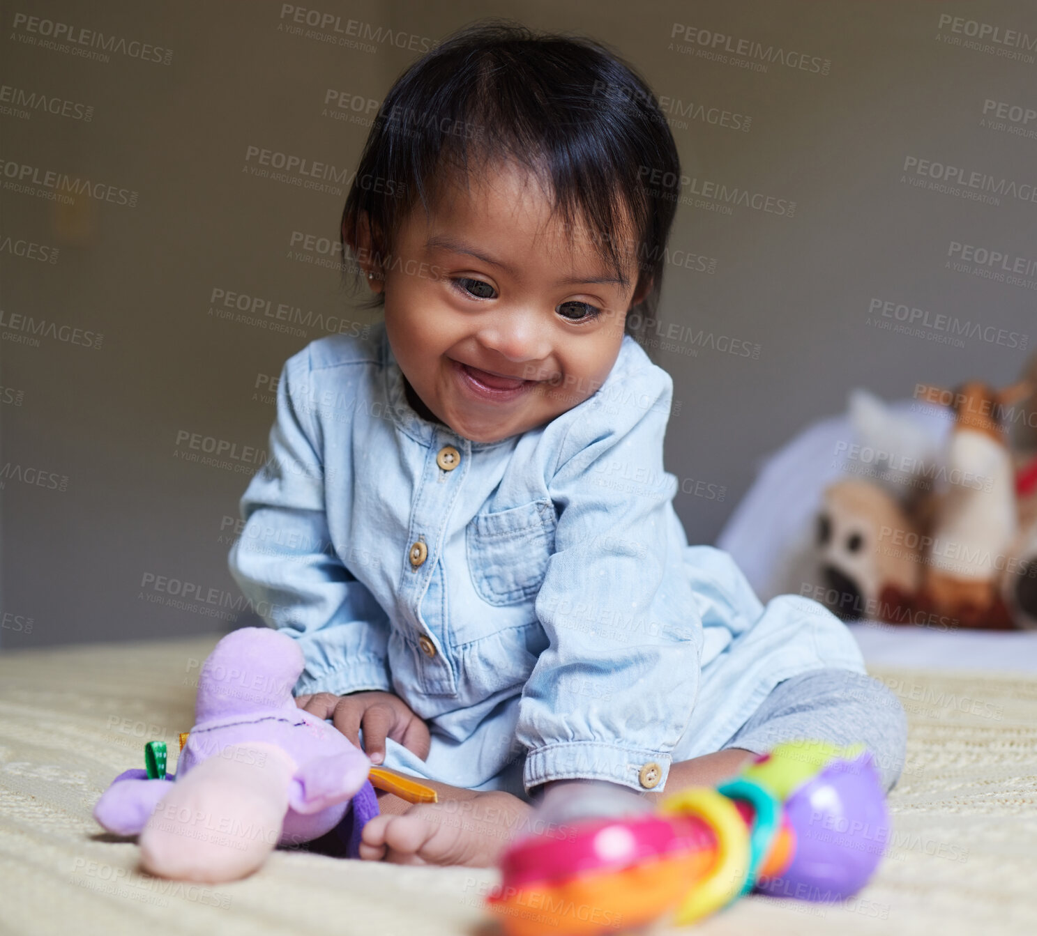 Buy stock photo Happy, smile and baby with down syndrome playing with toys for child development in a bedroom. Happiness, learning and girl child with disability or special needs having play time on a bed at home.