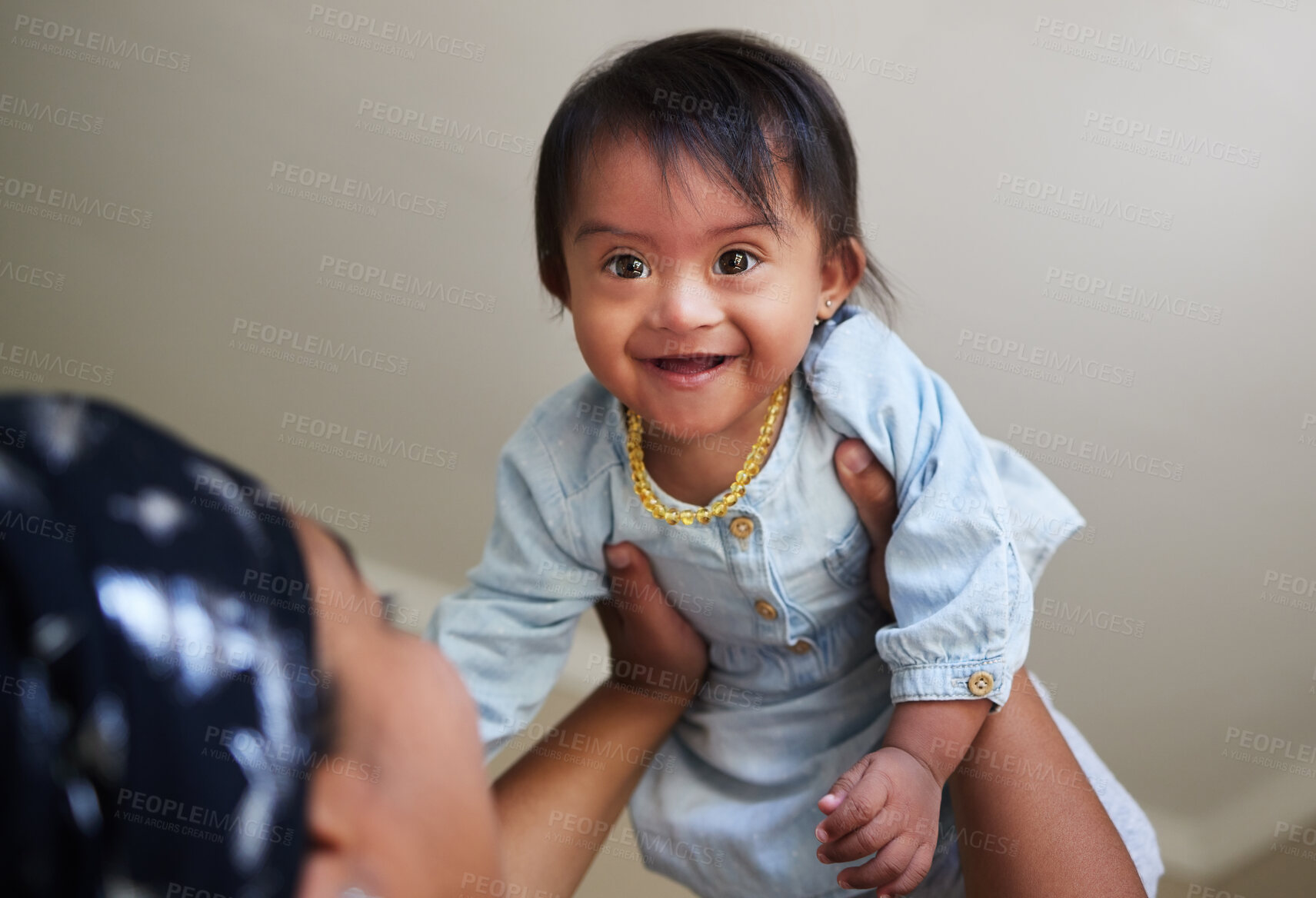 Buy stock photo Happy, down syndrome baby and child mom care of a woman holding a kid with a disability at a house. Happiness and smile of a young toddler special needs face from India in a home with a mother