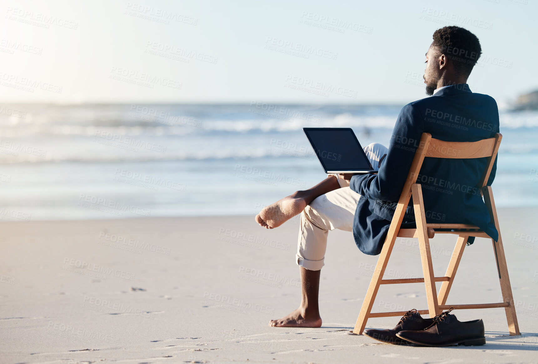 Buy stock photo Beach vacation, work travel and black man doing business on holiday reading an email with 5g internet while working by ocean. Relax, break and happy African male doing remote work on a chair in Bali