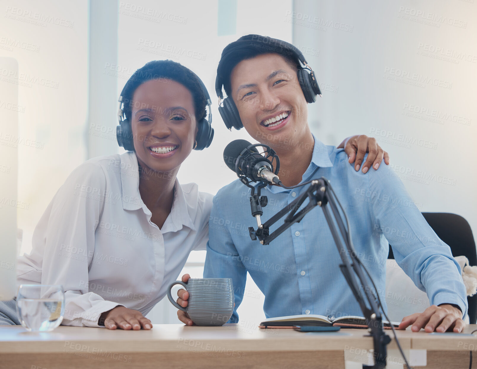 Buy stock photo Happy, smile and portrait of radio employees sitting in the studio with headphones and microphone. Interracial, professional and man and woman working in media recording podcast in creative workplace