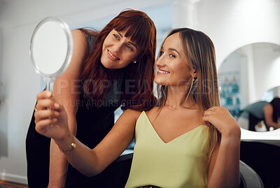 Buy stock photo Woman holding mirror at salon looking at new hair with hairdresser for professional beauty treatment. Smile, stylist and happy customer with fresh hairstyle and natural makeup in chair at hair salon 