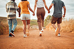Friends, walking and holding hands with a man and woman friend group taking a walk outside in nature or the dessert. Trust, support and vacation with people in the wilderness for travel and tourism