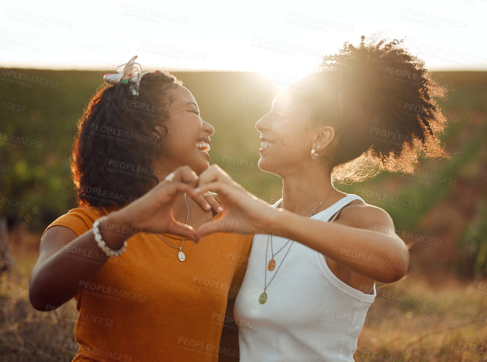 Buy stock photo Love, heart and hand sign by lesbian, couple travel and bond in nature at sunset, happy and relax. Freedom, romance and black women embracing in celebration of their relationship with emoji hands