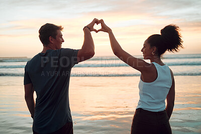 Buy stock photo Beach, couple and heart hand at sunset with happy people bonding together on Mexico holiday break. Care, love and trust in interracial romantic relationship with people enjoying ocean sky at dusk.