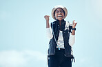 Winner, happy and black woman celebrate out in nature on hike, victory during adventure at summer vacation. Success, blue sky and travel,  laugh and freedom, carefree health and wellness journey.