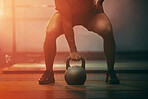Fitness, gym and sports training with kettlebell of athlete in exercise, workout and motivation indoors. Strong athletic ready with sport equipment exercising for strength, health and wellness