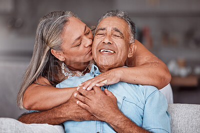 Buy stock photo Happy senior couple hug in home, retirement lifestyle together in Mexico and relax on sofa. Romantic marriage life, love bonding time and elderly woman kissing latino husband on cheek in living room