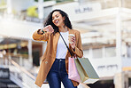 Time, shopping and woman with notification on watch with coffee in the city of Los Angeles. Happy, smile and girl walking with smart technology for fashion deal and retail bag in the mall after sale