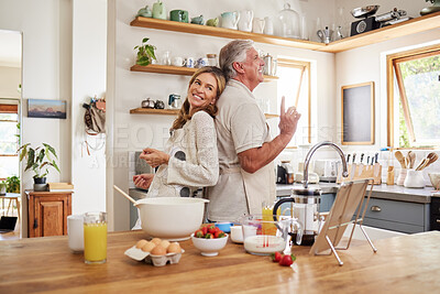 Buy stock photo Senior couple dance, cook breakfast in the kitchen and love making food together in retirement time. Elderly people smile, have fun cooking or baking pancakes and healthy meals while dancing at home 