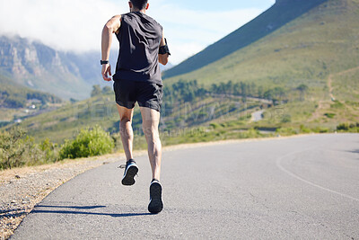 Buy stock photo Running, fitness and exercise with a sports man and runner outdoor on a road in nature for training. Workout, marathon and health with a male athlete on a run for sport on a road in the mountains