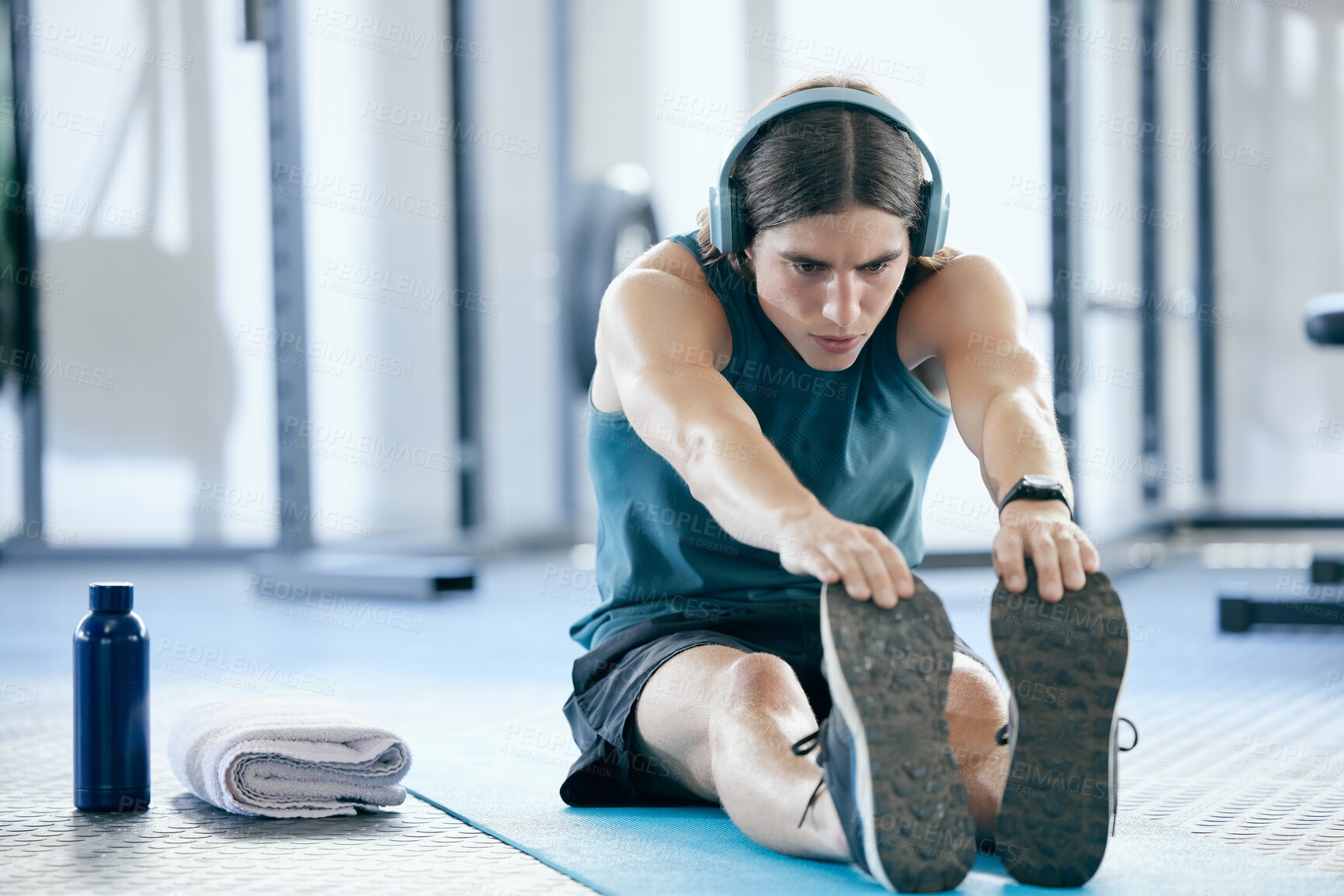 Buy stock photo Pilates, yoga and man stretching at gym for training or fitness exercise and streaming audio, music playlist or radio. Wellness, healthy and young athlete listening to podcast before starting cardio