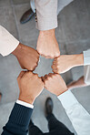 Fist, meeting and employees in a circle for support, team building and partnership in an office at work. Top view of hands of corporate workers for motivation, success and solidarity working together