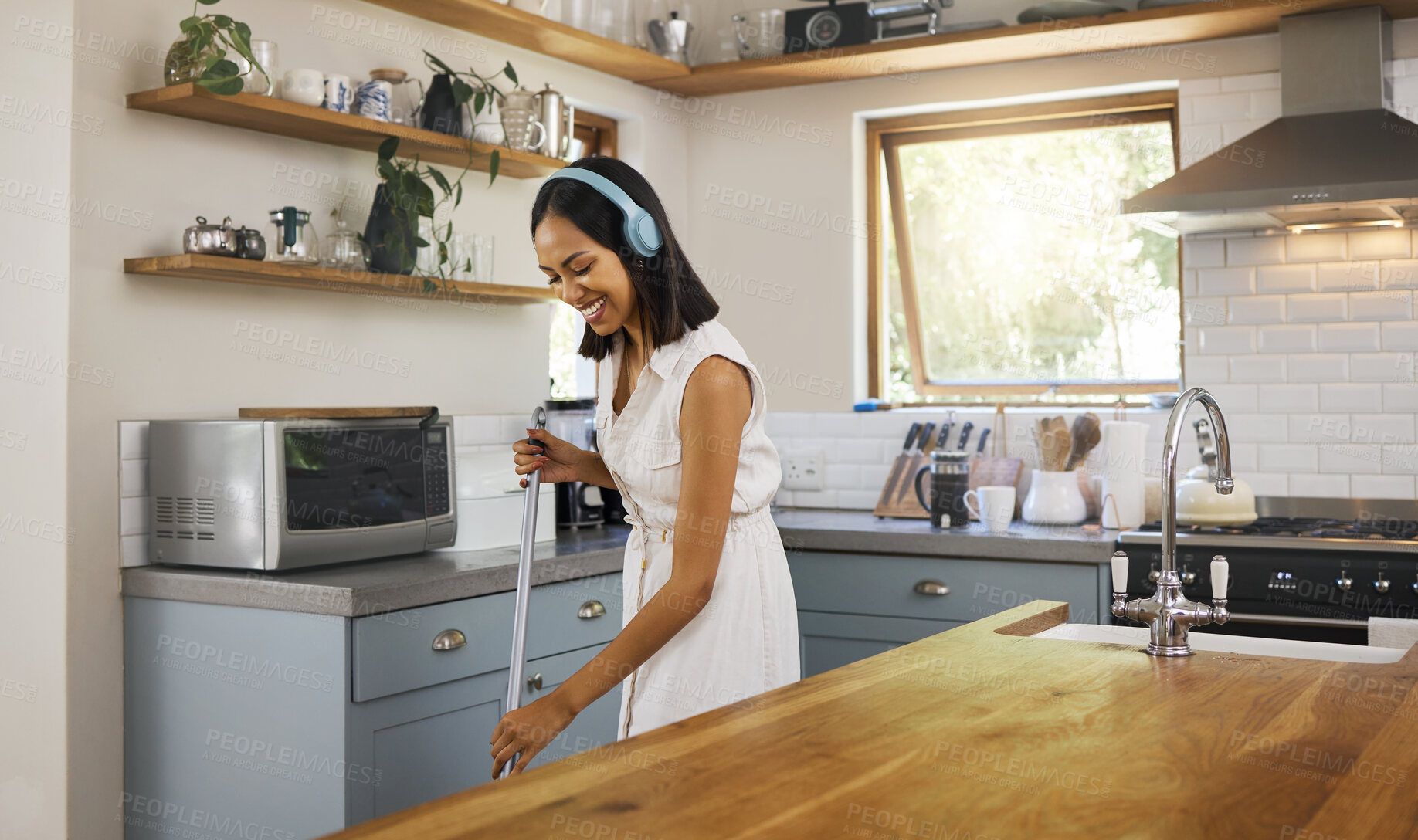 Buy stock photo Happy, headphones and woman cleaning the kitchen while listening to music, podcast or radio. Happiness, smile and girl cleaner or housewife washing the floors in a modern home, house or apartment.