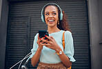 Black woman, smile and phone in social media with headphones in joy for 5G connection in the outdoors. Happy African American female student smiling for technology and internet on mobile smartphone